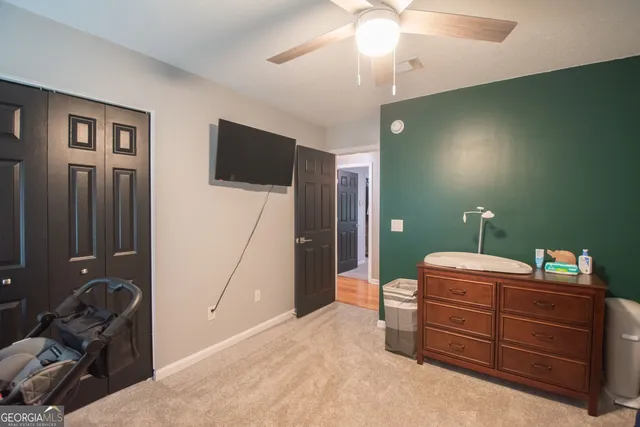 a bedroom with a bed and a mirror on the dresser