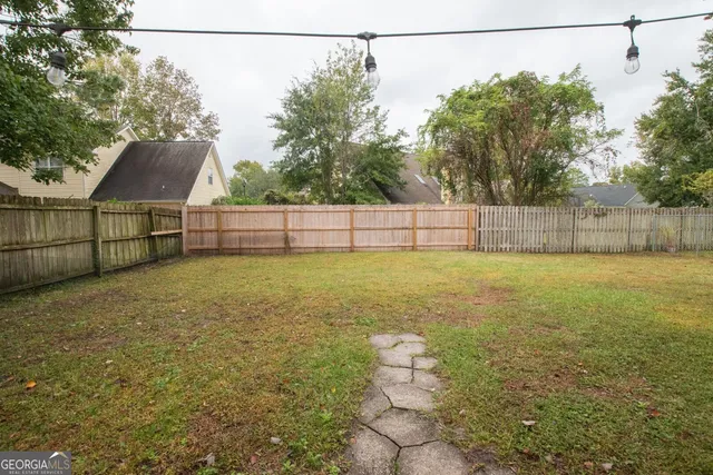 a view of a house with backyard and trees
