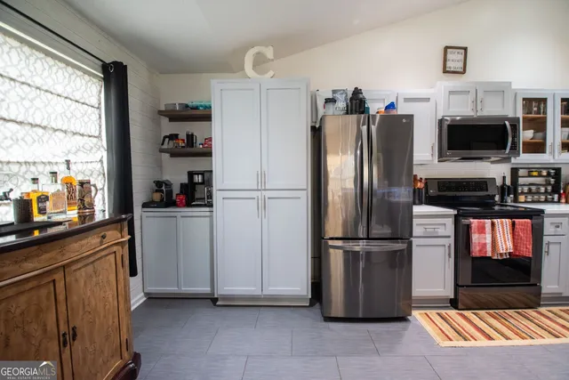 a kitchen with stainless steel appliances granite countertop a refrigerator and a stove top oven