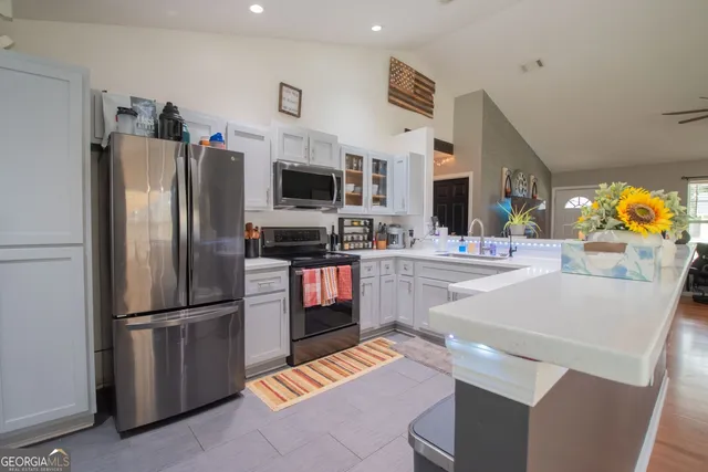 a kitchen with stainless steel appliances kitchen island granite countertop a refrigerator and a stove top oven
