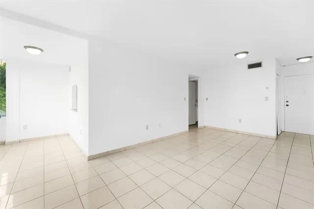 an empty room with white wall and tiles