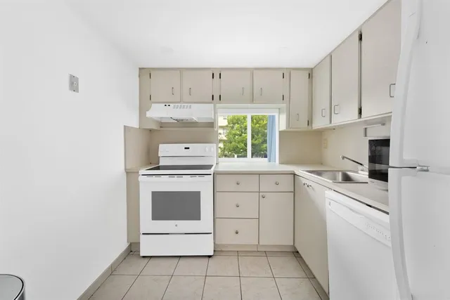 a kitchen with white cabinets and white appliances