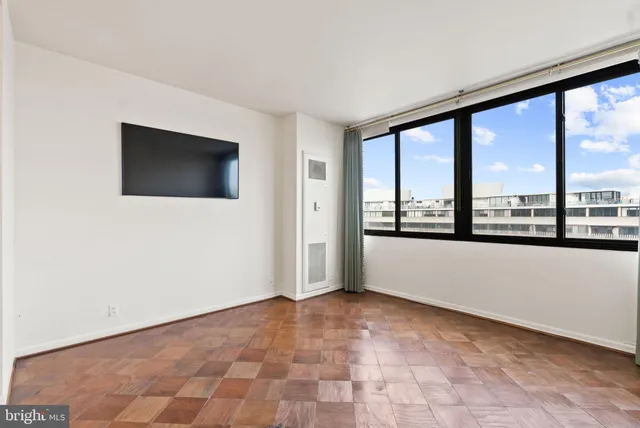 a view of an empty room with a window and a flat screen tv