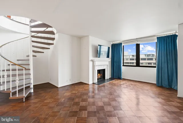 a view of an empty room with a fireplace and a window