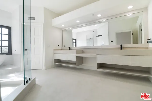 a large white kitchen with a white countertops and cabinets