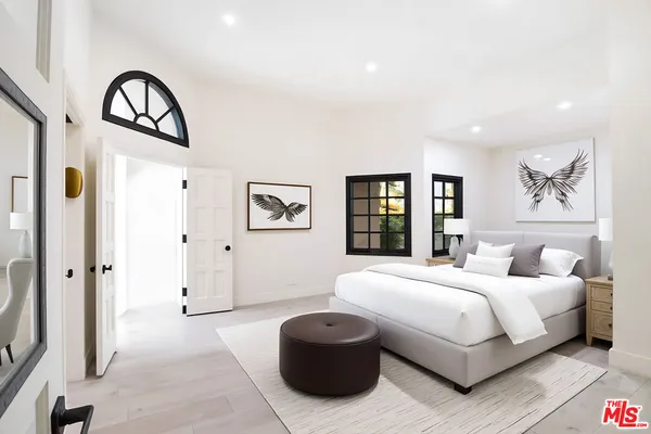 a bedroom with a bed and a large mirror