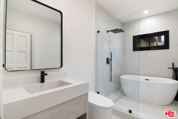 a bathroom with a toilet a sink a mirror and bathtub