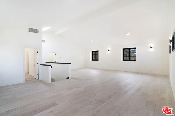 a view of a room with wooden floor and white walls