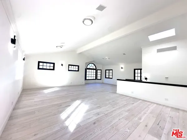 a view of a living room and kitchen with wooden floor