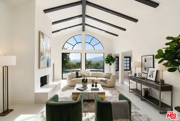 a living room with furniture a fireplace and a large window