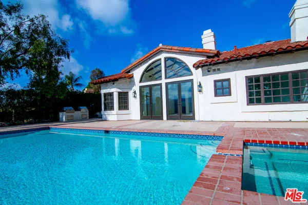 a front view of a house with swimming pool having outdoor seating