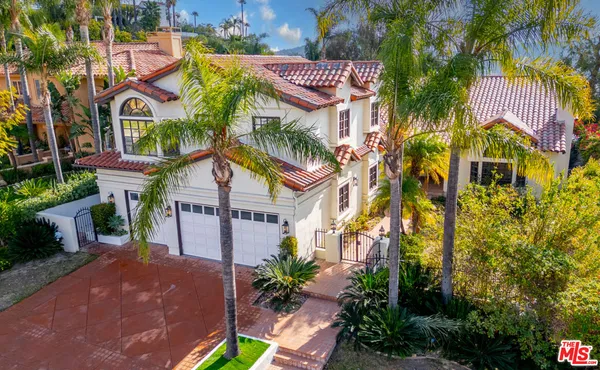 a front view of a multi story residential apartment building with yard and parking