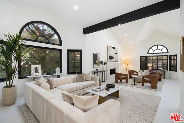 a living room with furniture a fireplace and a large window