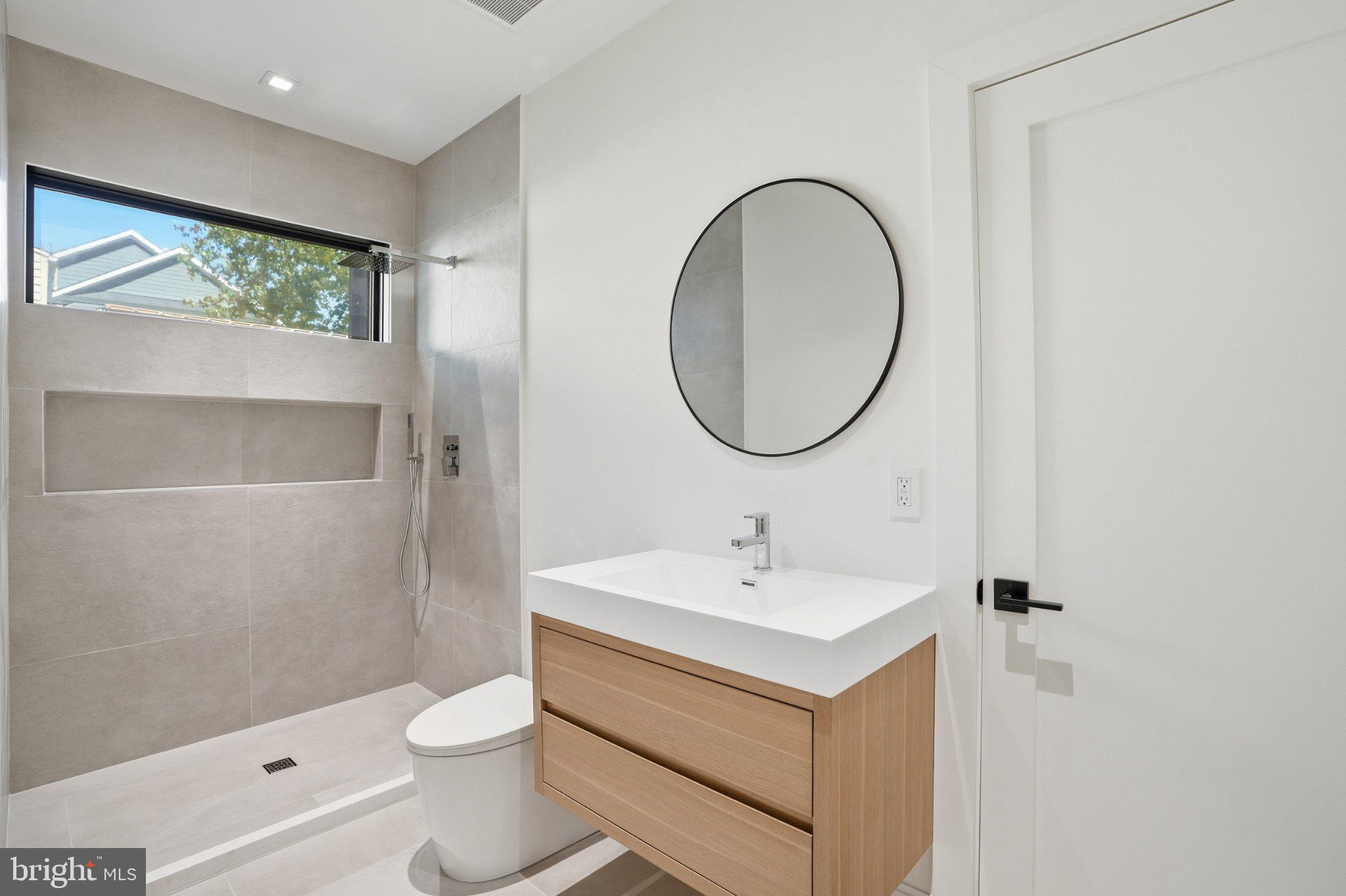 7421 Magarity Road Falls Church, VA 22043 - Photo 60 of 66 Sleek modern bathroom with natural light.