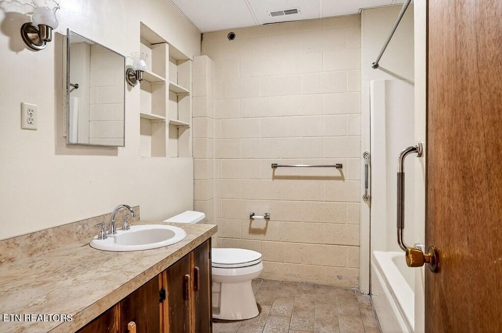 6211 Rocky Point Road Cookeville, TN 38506 - Photo 58 of 59 a bathroom with a granite countertop sink toilet and shower