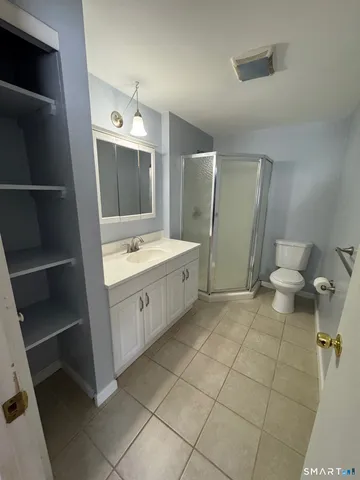 a spacious bathroom with a double vanity sink a toilet and a mirror
