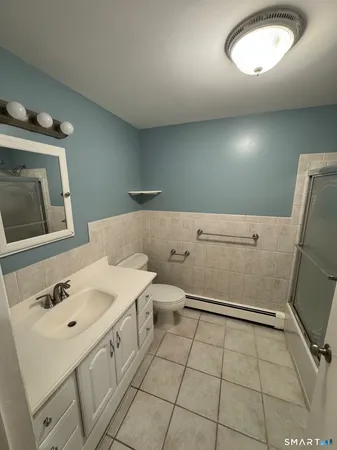 a bathroom with a sink a toilet and mirror