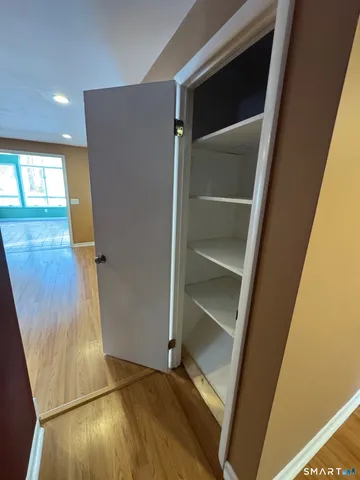 a view of walk in closet with wooden floor