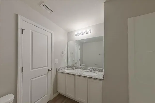 a bathroom with a granite countertop sink and a mirror