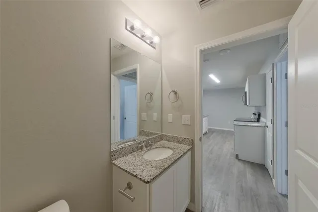 a bathroom with a granite countertop sink and a mirror