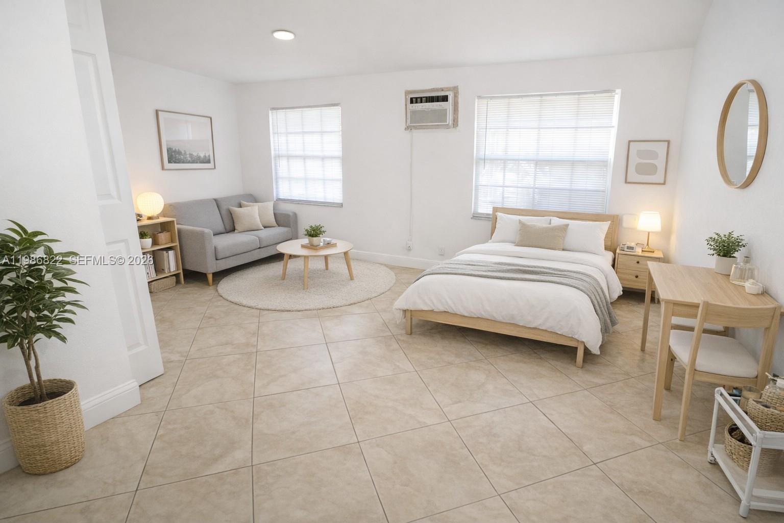 a spacious bedroom with a bed a couch and potted plant