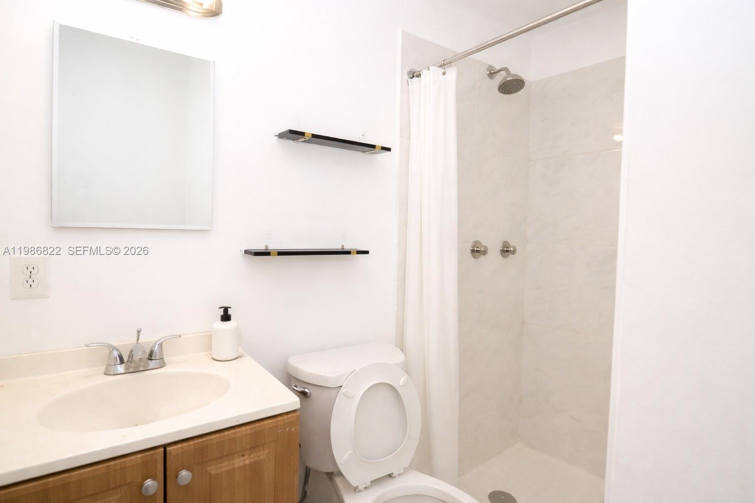 35 Virginia Road, Unit 1 West Park, FL 33023 - Photo 7 of 10 a bathroom with a sink toilet and shower