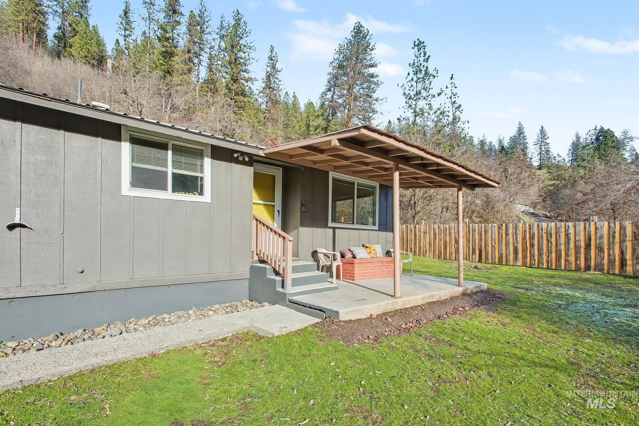 150 Elm Street Orofino, ID 83544 - Photo 24 of 36 Gray exterior siding with white trim, featuring a bright yellow entry door