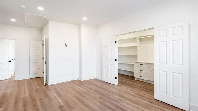 a view of walk in closet with wooden floor