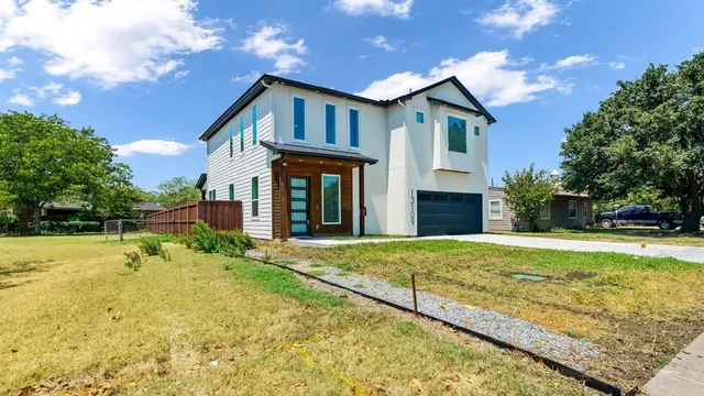 a front view of house with yard and trees in the background