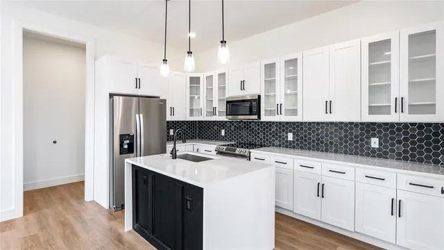 a kitchen with stainless steel appliances a sink a stove a refrigerator and cabinets
