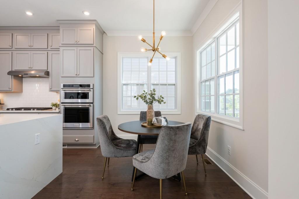 595 Hanlon Way Alpharetta, GA 30009 - Photo 10 of 33 a dining room with furniture a chandelier and wooden floor