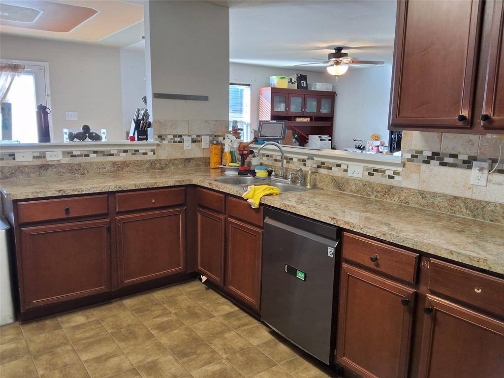 112 Hancock Street Venus, TX 76084 - Photo 8 of 25 Kitchen featuring wood-finish cabinetry, solid surface countertops, a mosaic tile backsplash, and a stainless steel dishwasher