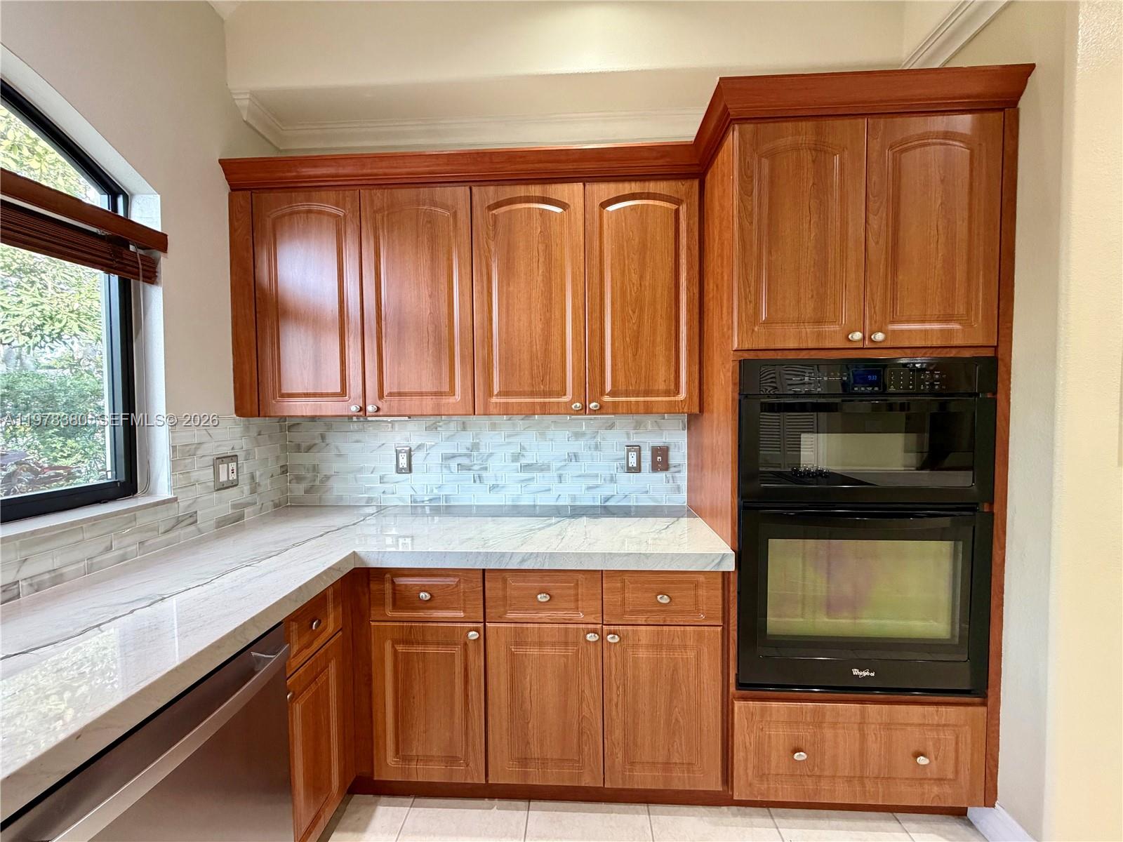 12391 Southwest 75th Street Miami, FL 33183 - Photo 31 of 89 a kitchen with stainless steel appliances granite countertop wooden cabinets a stove and a microwave
