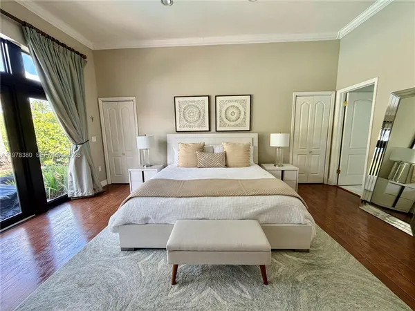 a bedroom with a bed a flat screen tv and a window