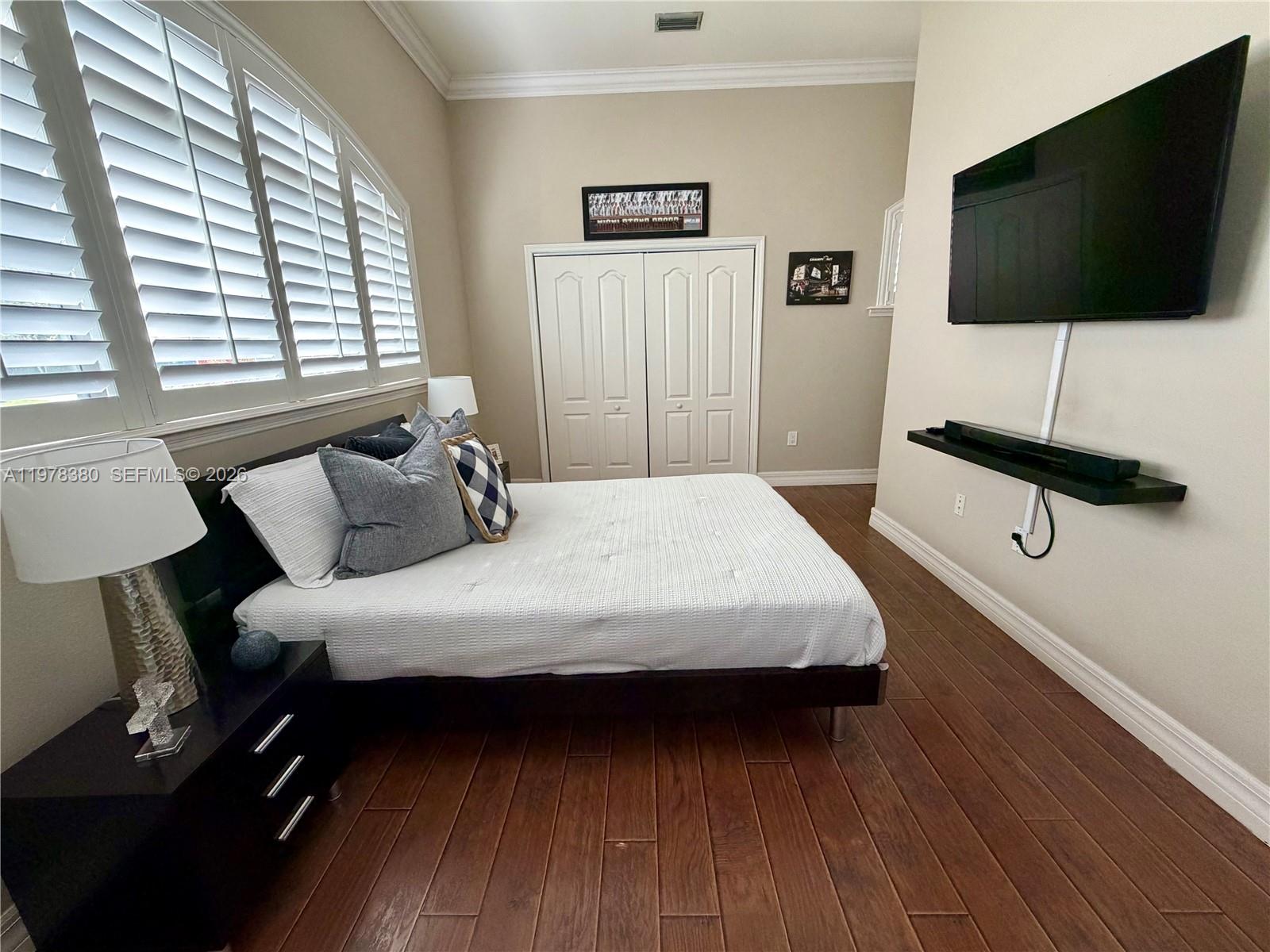 12391 Southwest 75th Street Miami, FL 33183 - Photo 58 of 89 a bedroom with a bed a flat screen tv and a window