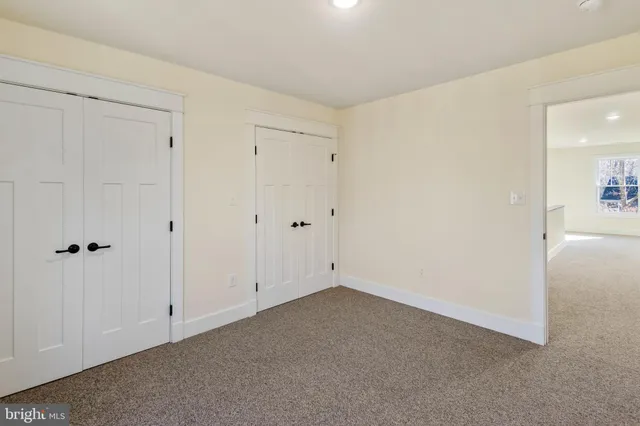 a spacious bedroom with a bed and a dresser