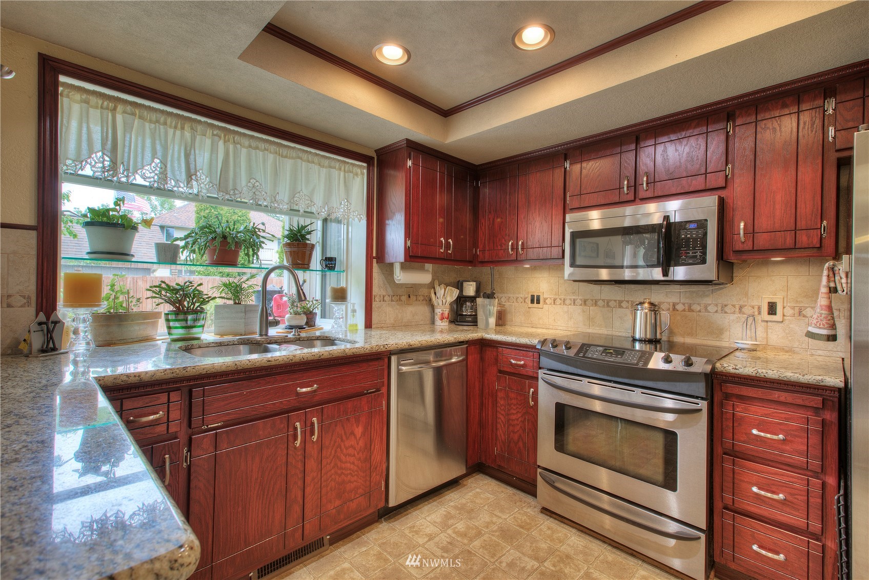 9216 South 239th Street Kent, WA 98031 - Photo 11 of 20 a kitchen with stainless steel appliances granite countertop wooden cabinets sink and a granite counter top