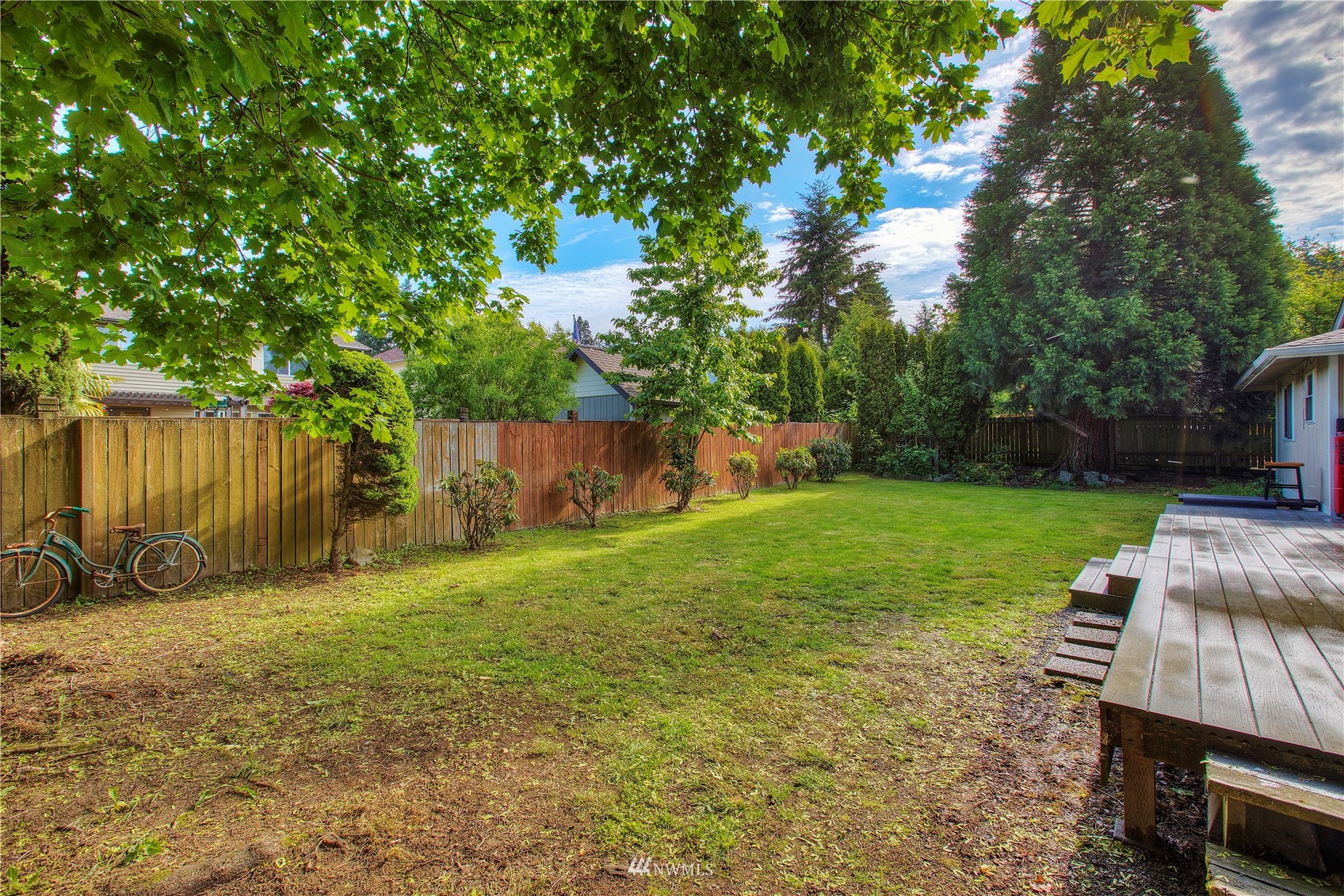 9216 South 239th Street Kent, WA 98031 - Photo 19 of 20 a view of a backyard with table and chairs a barbeque and a large trees with a swing