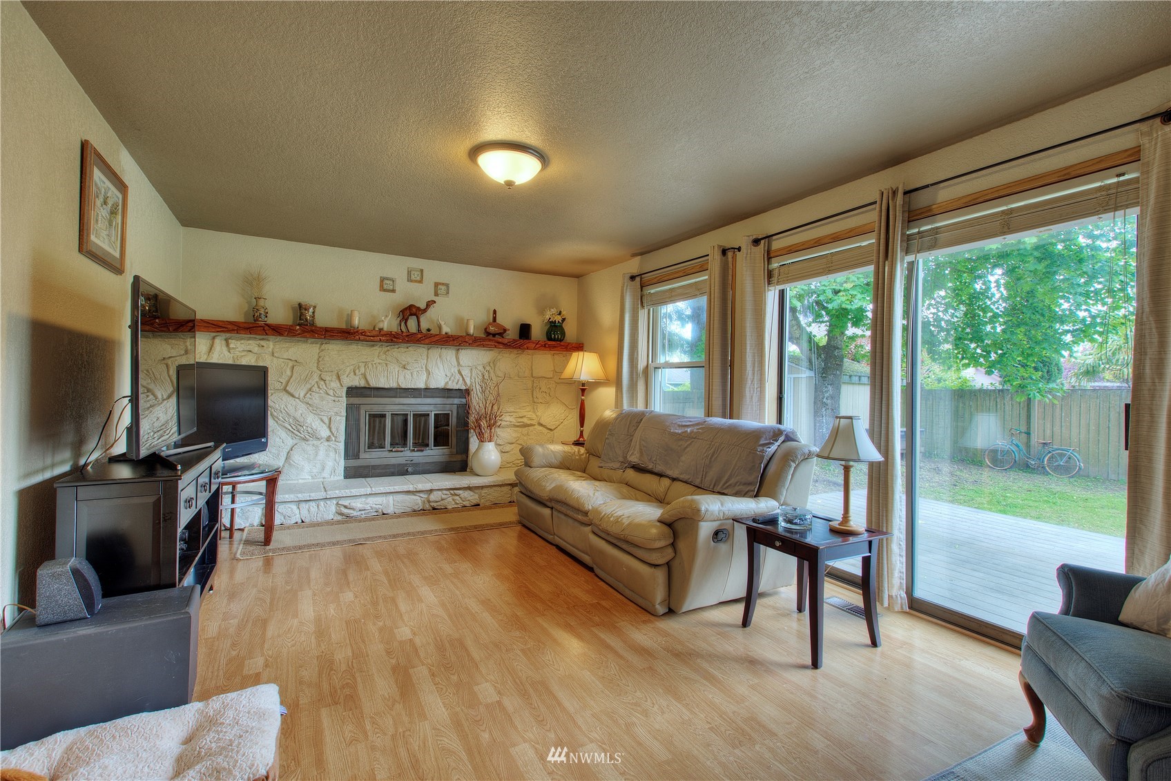 9216 South 239th Street Kent, WA 98031 - Photo 6 of 20 a living room with furniture a flat screen tv and a fireplace