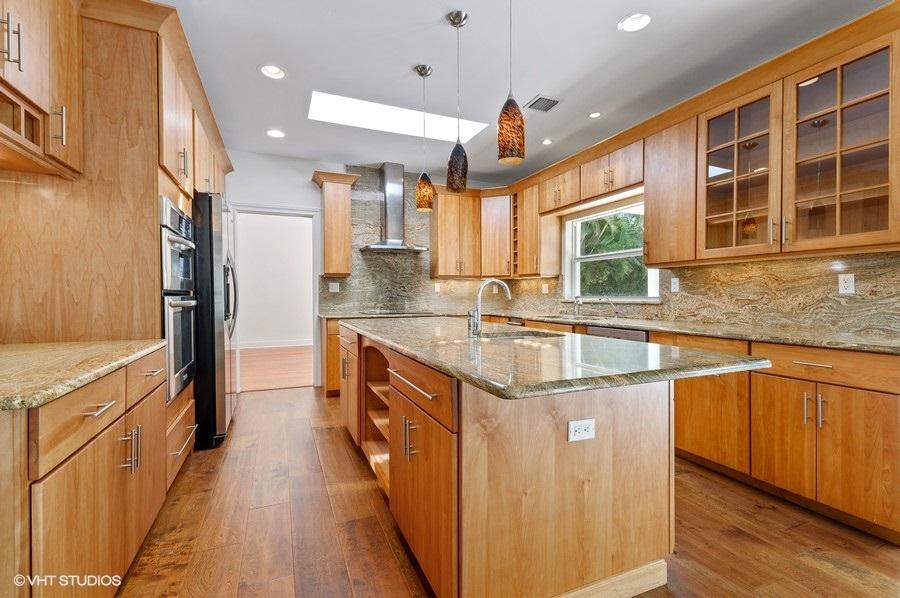 2730 Cardinal Circle Gulf Stream, FL 33483 - Photo 17 of 35 a kitchen with stainless steel appliances granite countertop a sink and a wooden floors