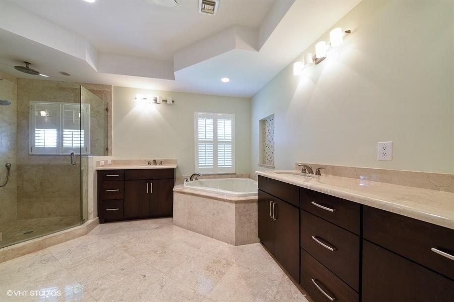 2730 Cardinal Circle Gulf Stream, FL 33483 - Photo 24 of 35 a spacious bathroom with a double vanity sink a toilet a mirror and shower