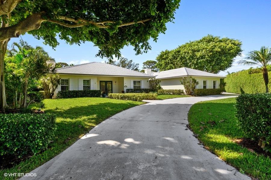 2730 Cardinal Circle Gulf Stream, FL 33483 - Photo 7 of 35 a view of a white house with a yard plants and large tree