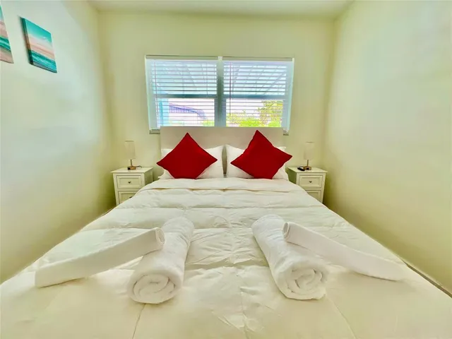 a large bed sitting in a bedroom next to a window