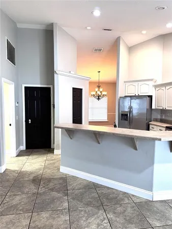 a view of a kitchen with kitchen island a sink stainless steel appliances and cabinets