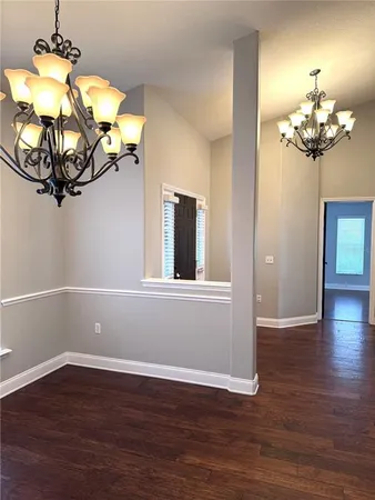 a view of a room with wooden floor and chandelier