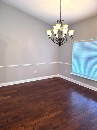 a view of a room with wooden floor and chandelier