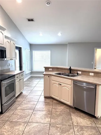 a kitchen with stainless steel appliances granite countertop a sink and a stove