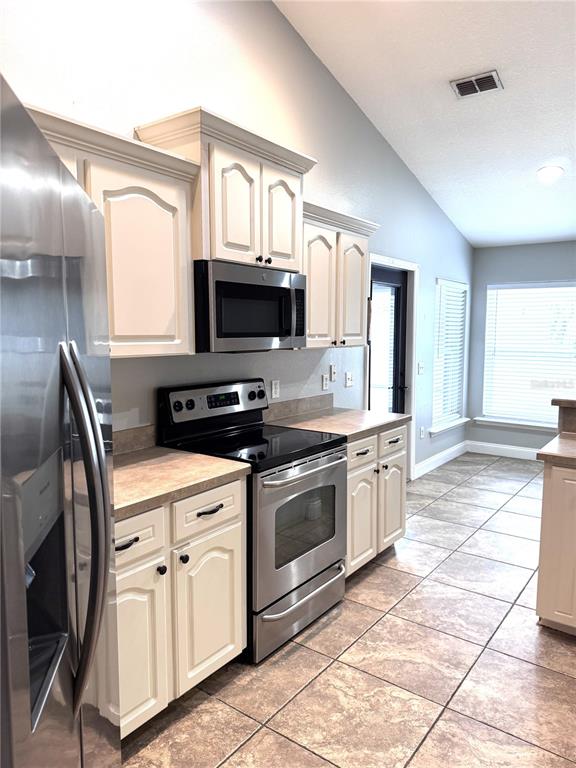 2616 Hickory View Loop Lakeland, FL 33813 - Photo 10 of 39 a kitchen with stainless steel appliances granite countertop a stove a sink and a refrigerator