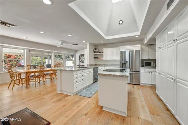 a large white kitchen with lots of counter space and stainless steel appliances