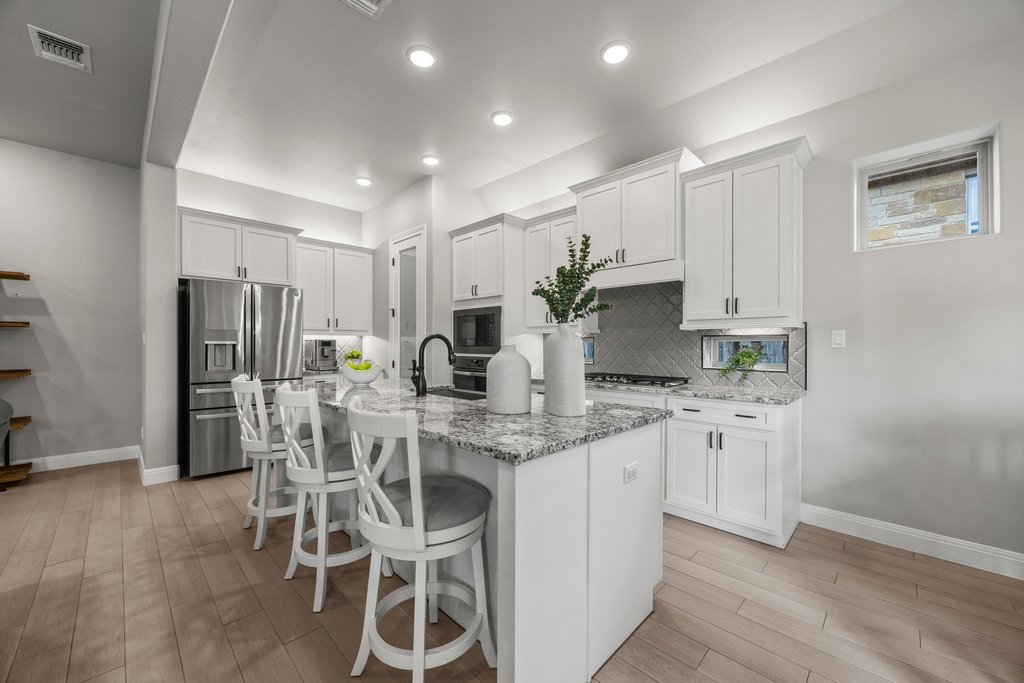 308 Morning Ridge Georgetown, TX 78628 - Photo 21 of 33 a kitchen with white cabinets and stainless steel appliances